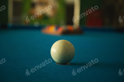 Preview: A white pool ball rests on a blue surface ready for the next shot