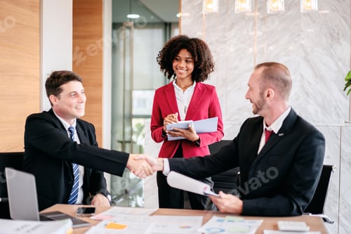 Preview: Three people in suits shaking hands in a conference room