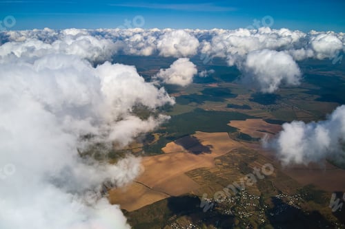 Preview: Aerial view from high altitude of earth covered with white puffy cumulus clouds on sunny day