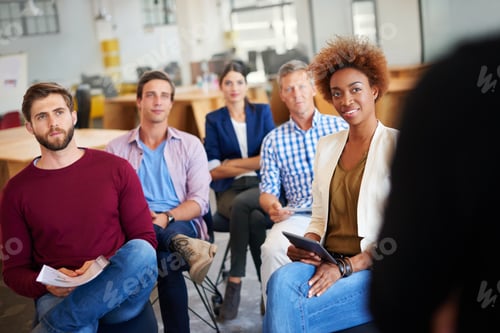 Preview: As knowledge increases, wonder deepens. A group of colleagues listening to a presentation.