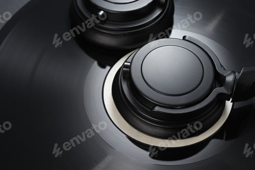 Preview: Vinyl record with black headphones close-up.