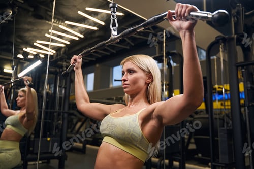 Preview: Concentrated blonde female person training in the gym