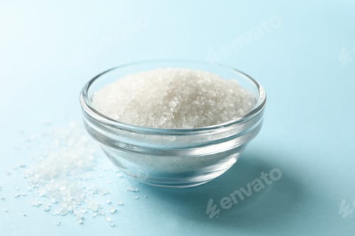 Preview: Glass bowl of salt on blue background