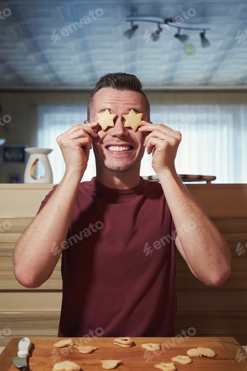 Preview: Playful Man Holds Star Cookies Over Eyes