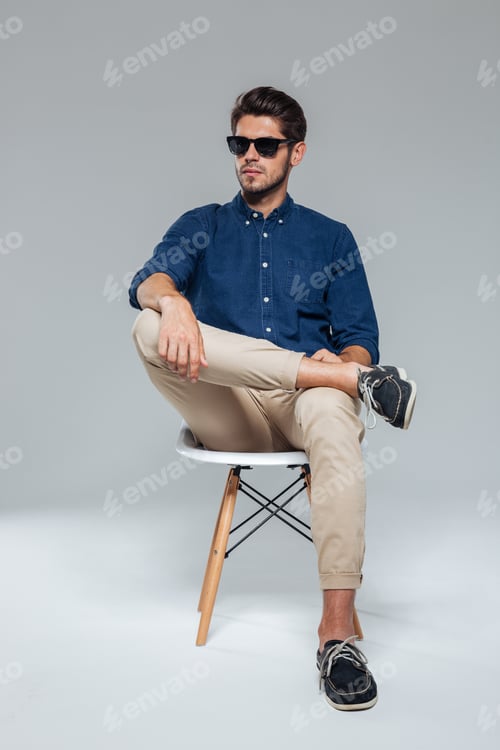 Man in Blue Shirt Posing on Chair