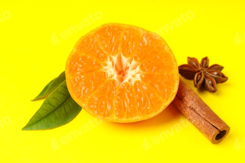 Preview: Mandarin with leaves and cinnamon on yellow background