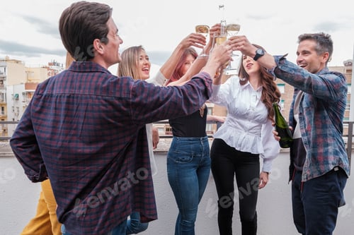 Preview: Group of friends toasting and celebrating together on the terrace of the building.