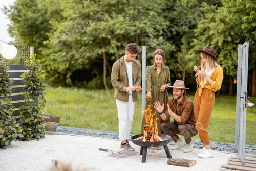 Visualização: Grupo de jovens amigos se divertem junto a uma lareira no quintal