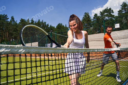 Preview: Joyous tennis player and her partner perfecting their serve technique
