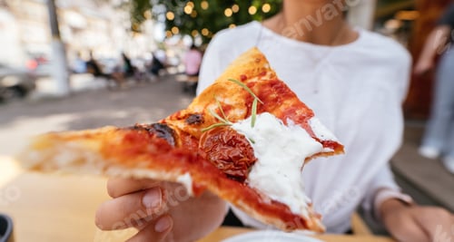 Preview: Woman's hand holding a pizza outdoor