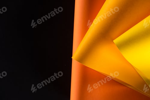 Preview: orange and yellow papers isolated on black