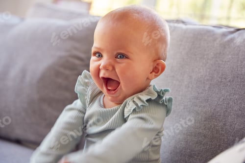 Preview: Cute Baby Girl Sitting On Sofa Playing Laughing And Smiling