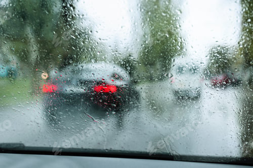 Preview: Blurred view of road through wet car window. Rainy weather