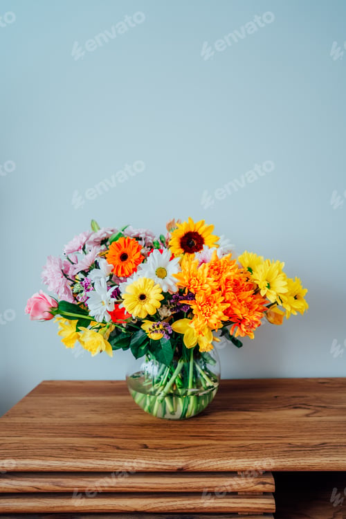 Preview: Vase with huge multicolor various mixed flower bouquet on the wooden sideboard
