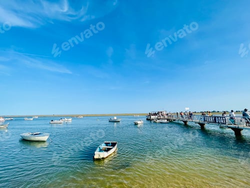 Preview: Canal de Tavira . Small boat cruising tranquil green river.