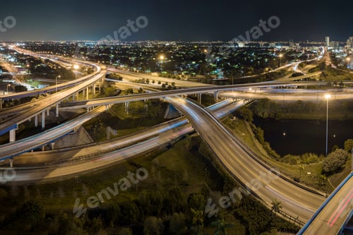 Preview: Aerial view of american freeway intersection at night with fast driving cars and trucks