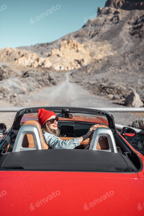 Preview: Woman traveling by cabriolet car on the desert road