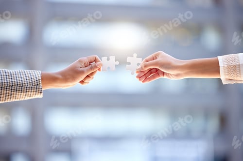 Preview: Shot of two unrecognizable businesspeople holding two puzzle pieces against a city background