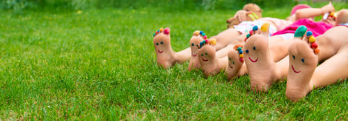 Preview: Children's feet painted on the grass. Selective focus.