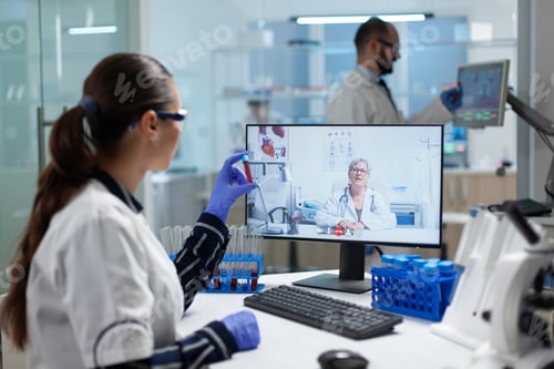 Preview: Biologist researcher woman holding blood test tube in hands discussing medical vaccine