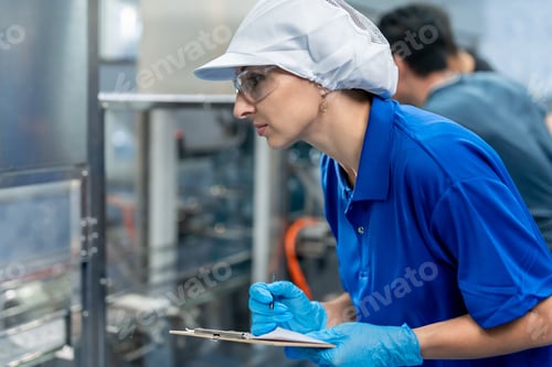 Preview: Caucasian female industry worker working alone in factory warehouse.