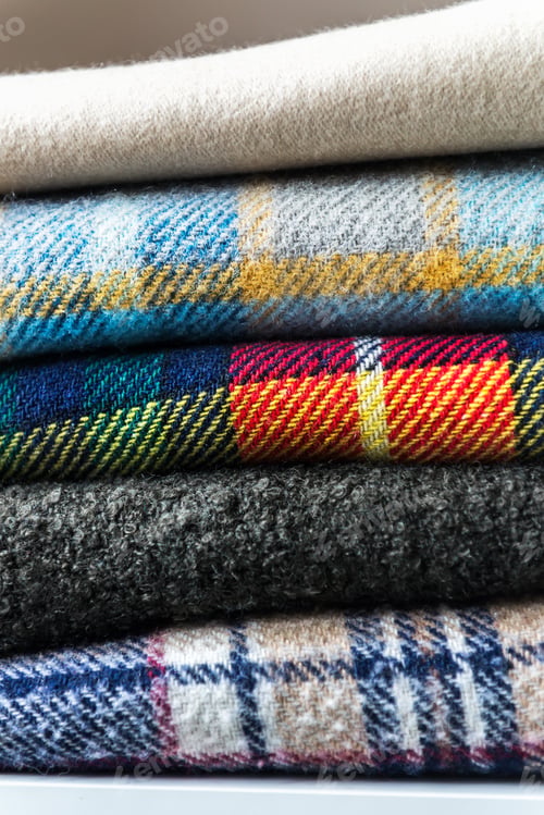 Preview: Stack of woolen checked blankets