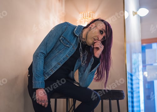 Preview: Portrait of an eccentric rocker with a denim jacket. He has long purple hair.
