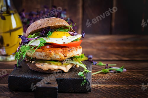 Preview: Hamburger. Sandwich with chicken burger, tomatoes, pickled cucumber and fried egg