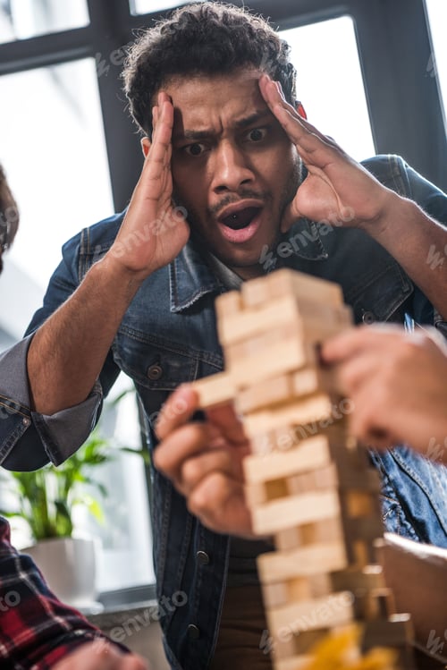 Preview: portrait of excited man looking at jenga game process