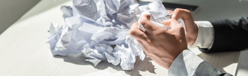 Preview: Cropped view of businessman with hands near pile of crumbled papers on blurred background, banner