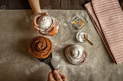 Preview: Children's hand takes a freshly baked cinnamon bun