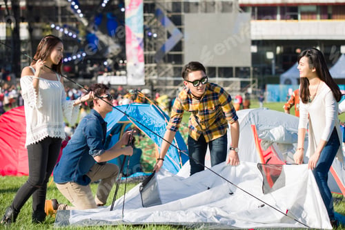 Preview: Friends setting up a tent on the grass