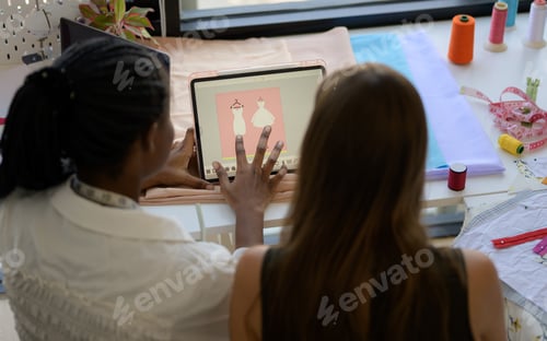 Preview: Happy female dressmaker working in workshop studio