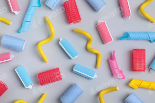 Preview: Different hair curlers on light grey background, flat lay. Styling tool