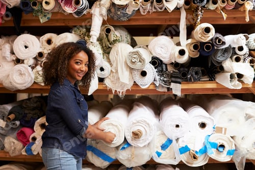 Preview: Mixed race woman selecting fabrics looking to camera