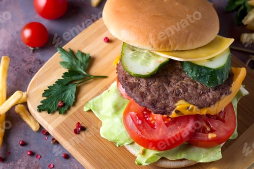 Preview: Tasty grilled home made burger cooking with beef, tomato, cheese, cucumber and lettuce. Top view