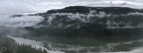 Preview: Misty Mountain Lake With Fog Over Forested Peaks and Reflections in British Columbia, Canada