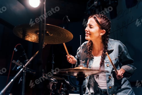 Preview: Plays drums. Young beautiful female performer rehearsing in a recording studio