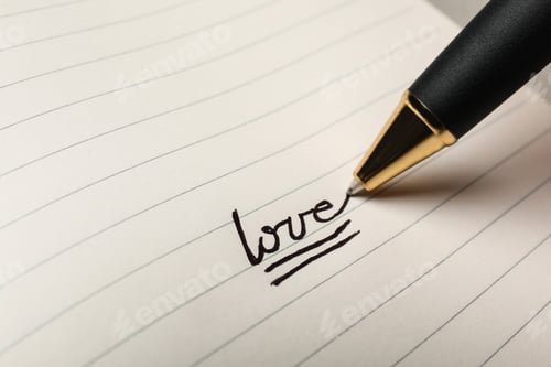 Preview: Writing word LOVE in journal, closeup view