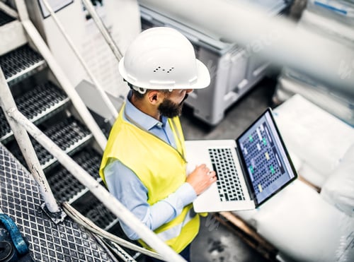 Preview: A portrait of an industrial man engineer with laptop in a factory, working.