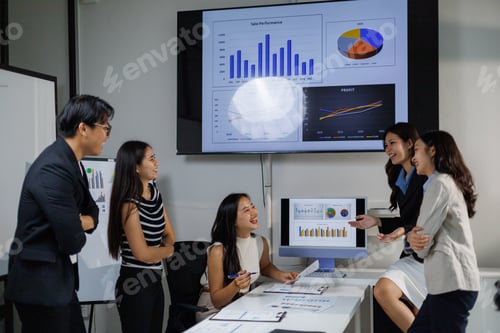 Preview: Business team analyzing financial charts and celebrating positive results in office meeting