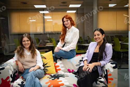 Preview: Three women seated on a colorful couch.
