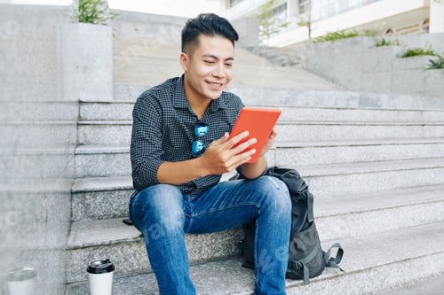 Preview: Smiling man reading article online