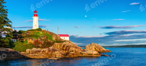Preview: Lighthouse on a rocky coast during a cloudy sunset.
