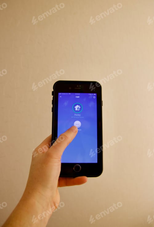 Preview: Woman adjusting smart thermostat to eco friendly mode from app on phone