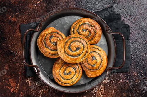 Preview: Sweet twisted Bun with poppy seeds and lavender. Dark background. Top view