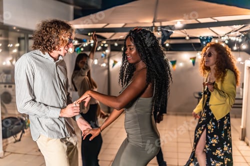 Preview: Multi-ethnic friends dancing holding hands latin music at night party