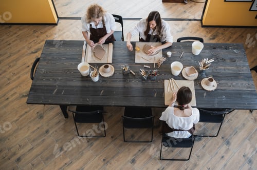 Preview: Caucasian female best friends pottery artists decorating a ceramic pod, talking and smiling during