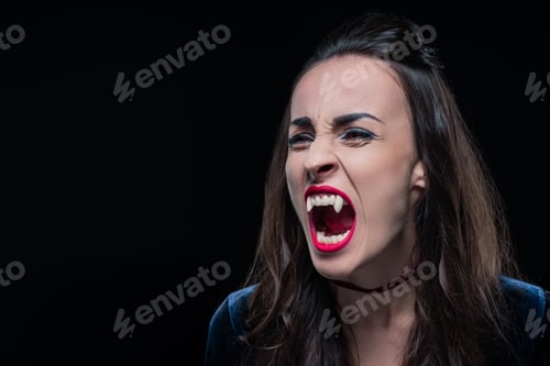 Preview: dreadful woman showing vampire teeth isolated on black