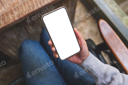 Preview: Top view mockup image of a woman using and holding mobile phone with blank screen